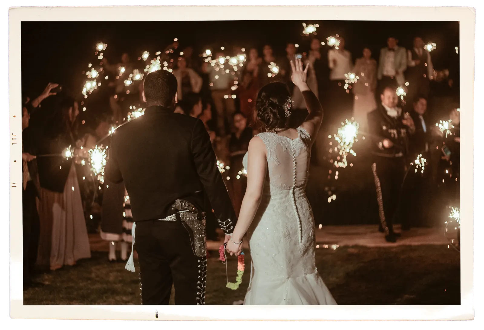 Los novios caminando entre luces de bengala al final de la fiesta
