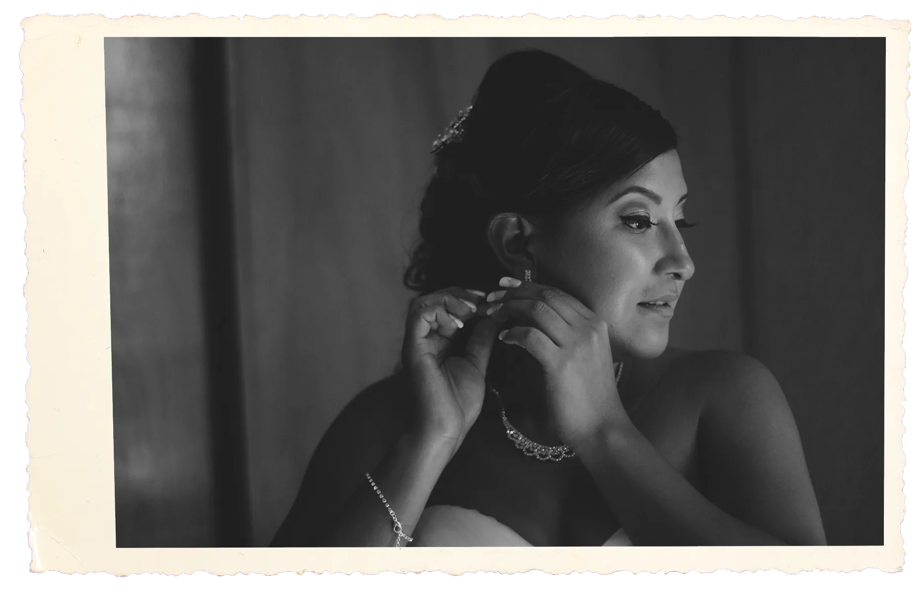 Novia colocándose un arete antes de la boda, retrato en blanco y negro