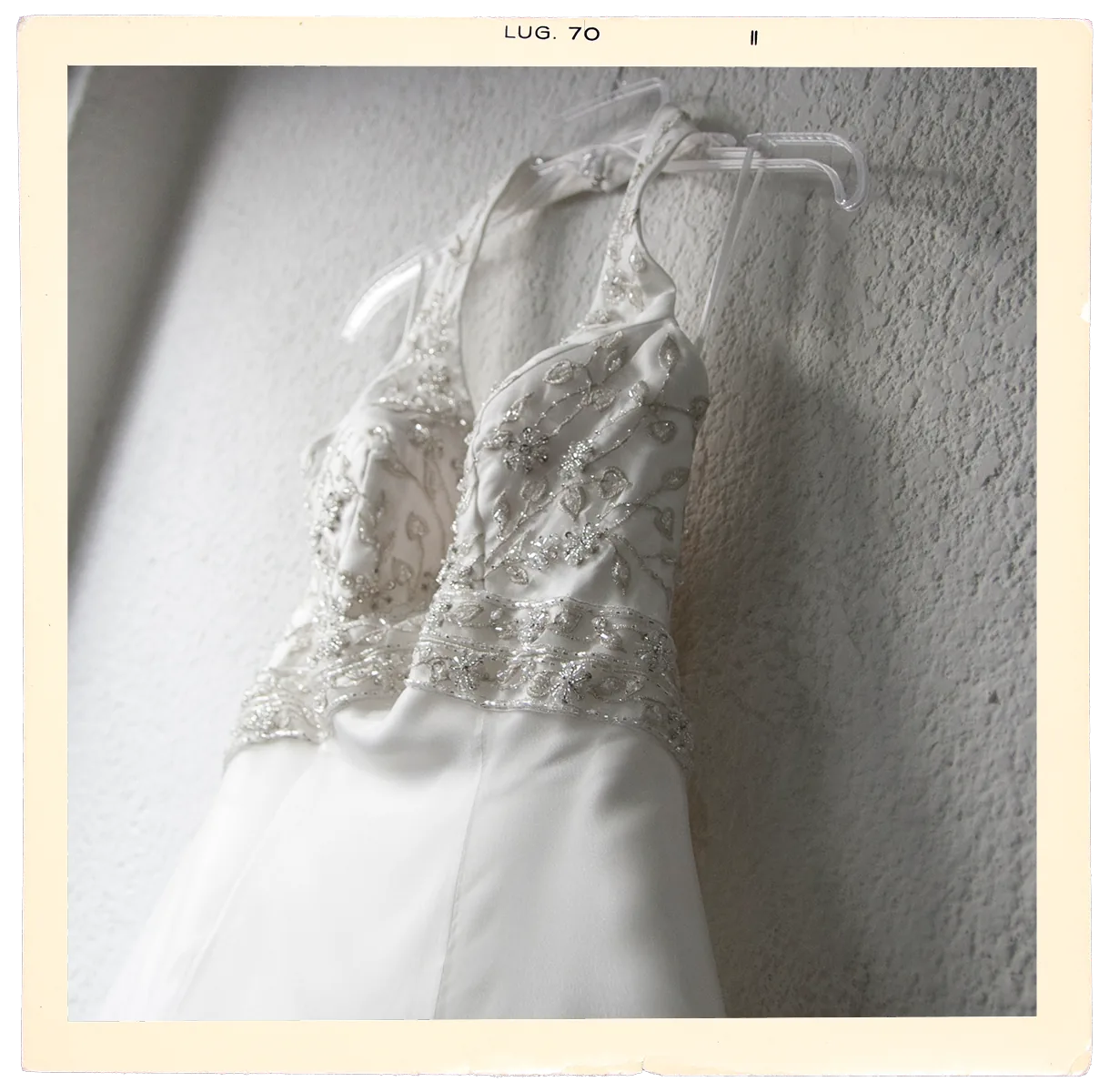 Vestido de novia colgado en la pared antes de la boda