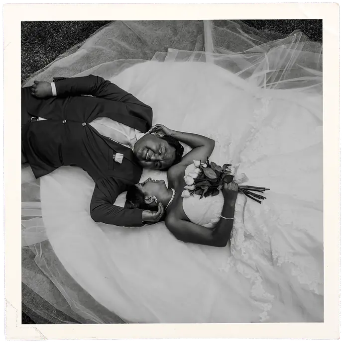Los novios recostados sobre el velo, retrato en blanco y negro